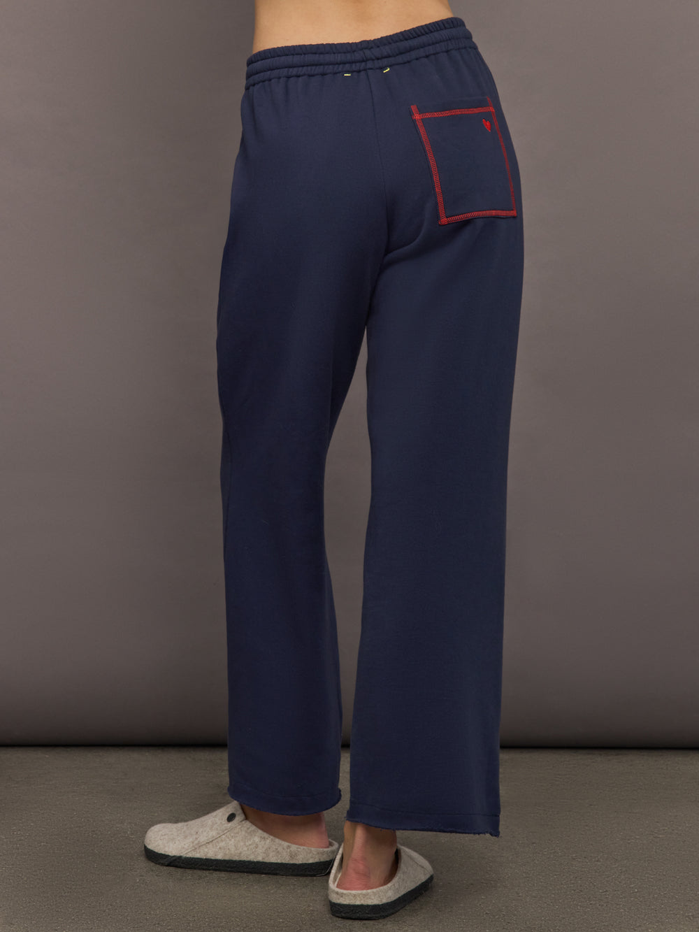 Back view of indigo blue sweatpants highlighting contrast pocket detail.