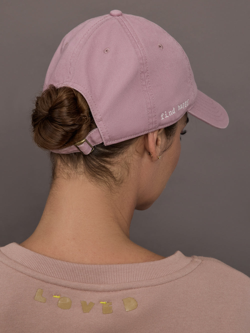 Model is wearing KR Imperfect Chenille Heart Hat in mauve, back view with adjustable strap.