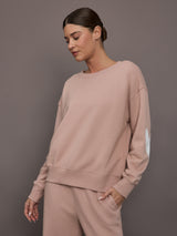Model is wearing Ex-Boyfriend fleece relaxed crewneck sweatshirt in mauve, front three-quarter view.