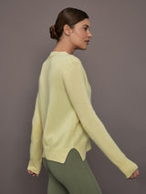 Model is wearing Featherweight Cashmere Button Cardigan in Lemon Tint, side view.