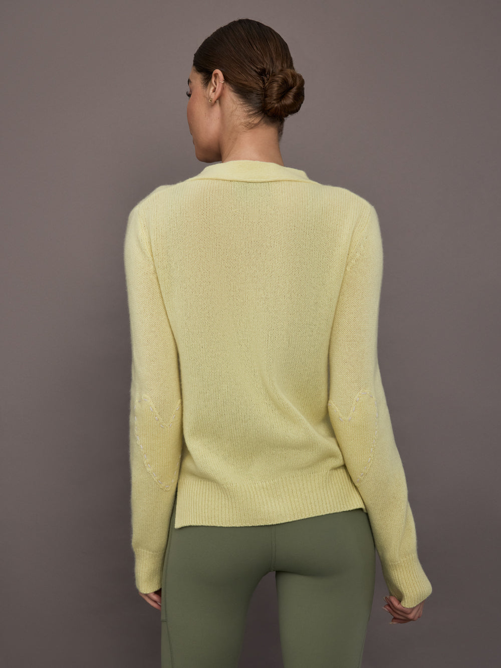 Model is wearing Featherweight Cashmere Button Cardigan in Lemon Tint, back view.