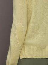 Model is wearing Featherweight Cashmere Button Cardigan in Lemon Tint, elbow heart detail close-up.