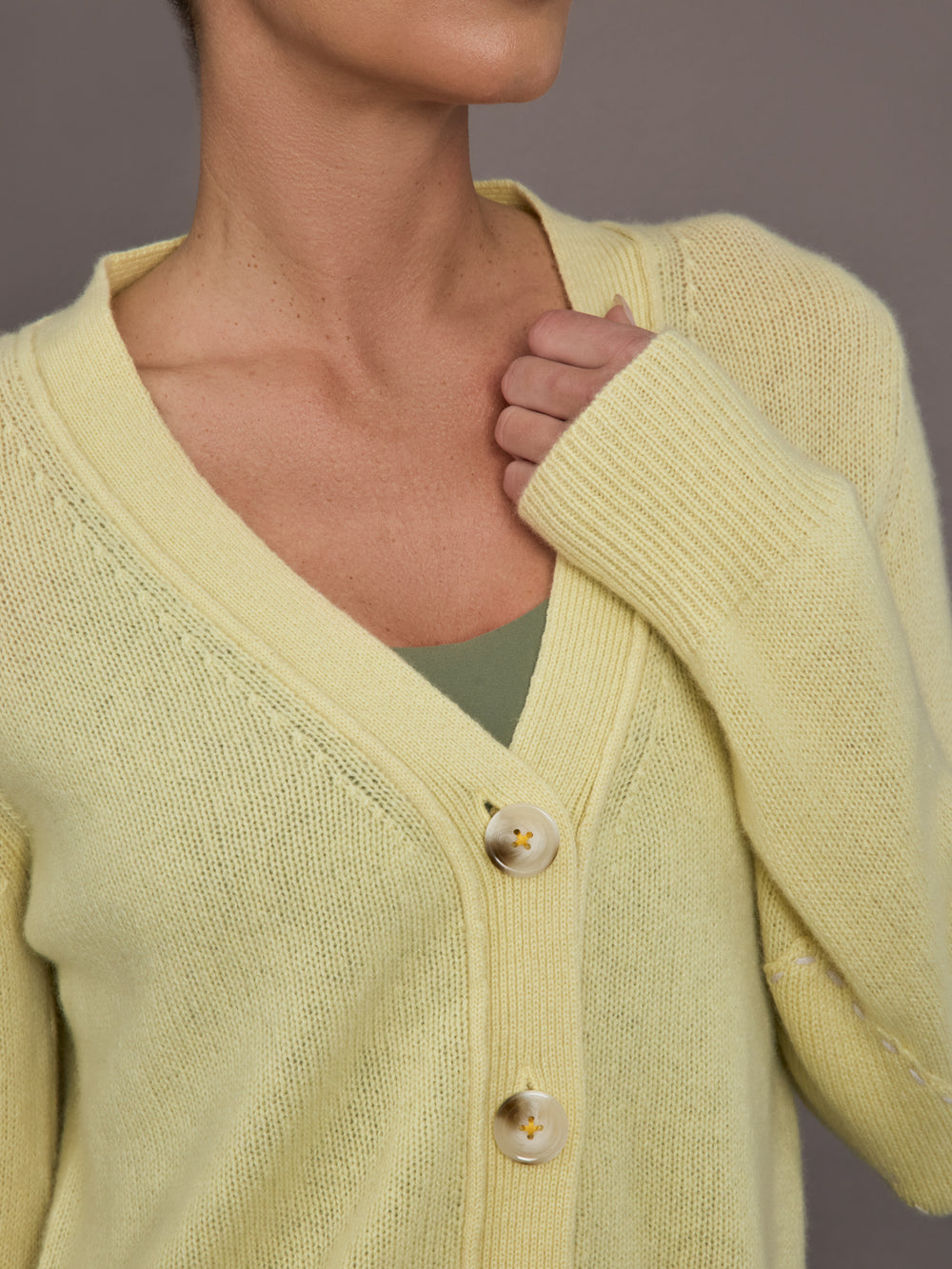 Model is wearing Featherweight Cashmere Button Cardigan in Lemon Tint, button and neckline close-up.