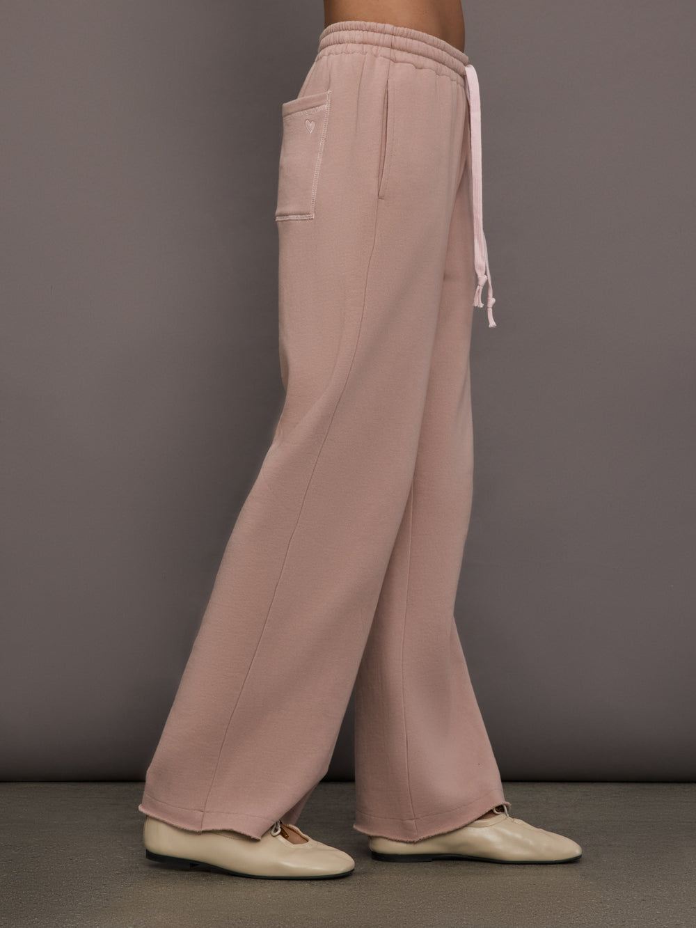 Model is wearing Weekend Barb fleece sweatpant in Mauve, side view.
