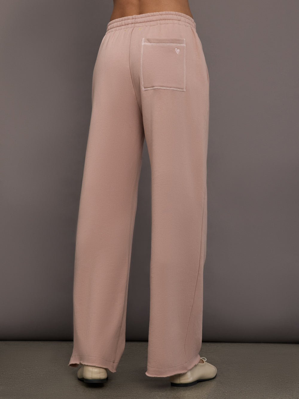 Model is wearing Weekend Barb fleece sweatpant in Mauve, back view.
