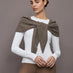 Model wears a muted brown colored hooded scarf over her shoulders. 