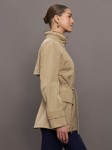 Model is wearing a tan colored rain jacket with a cinched waist.