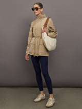 Model is wearing a tan colored rain jacket with a cinched waist.