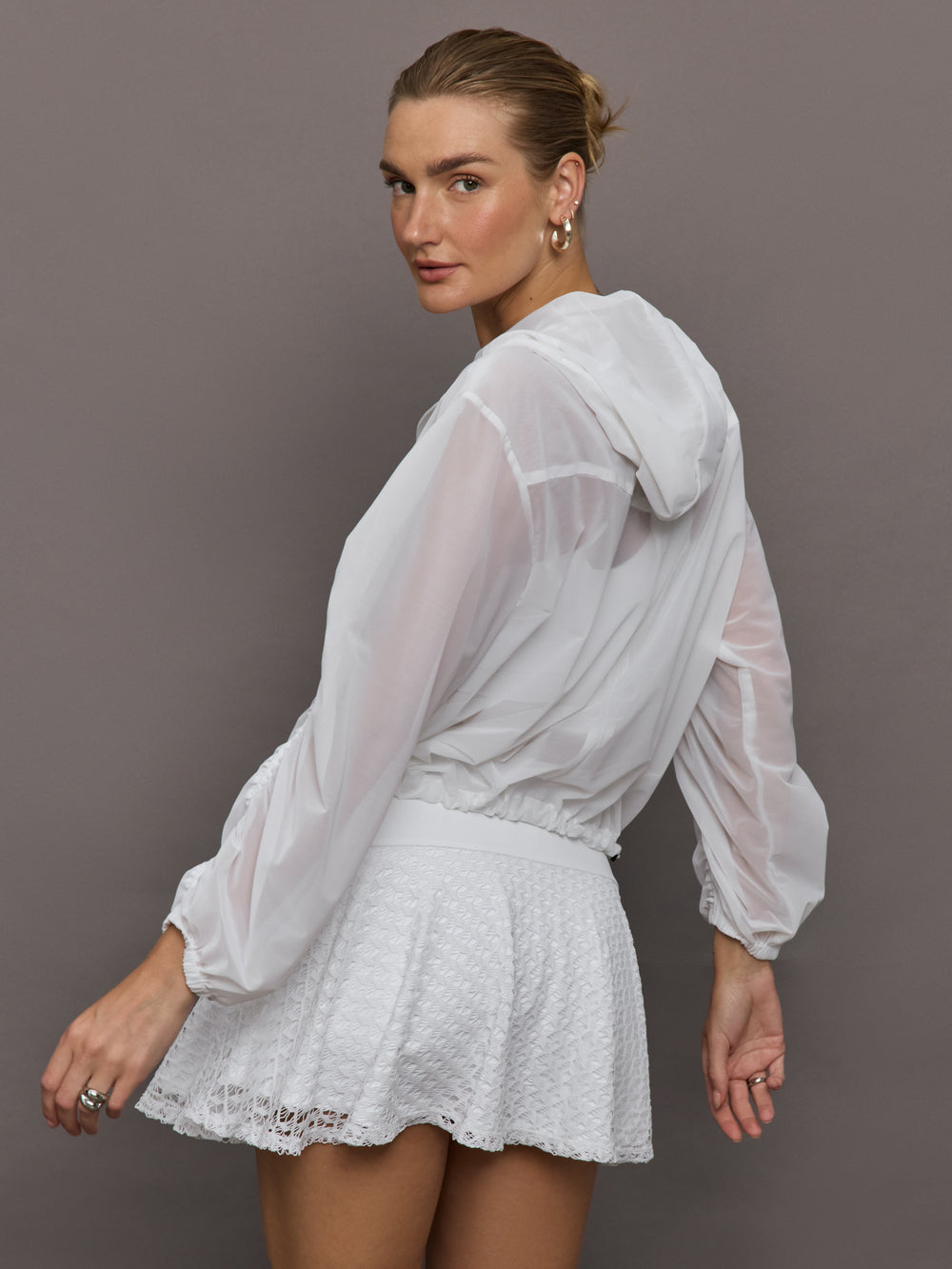 Model wears white Indy Jacket with a relaxed fit and full zip front, with elastic cuffs and a sheer, lightweight fabric for a translucent look.