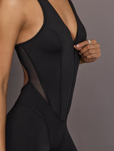 Model is wearing the Odyssey Jumpsuit in black, front zipper detail close up.