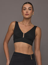 Model is wearing the Onyx Longline Bra Black, front view highlighting the ruched detailing and metallic U-ring at center front.
