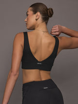 Model is wearing the Onyx Longline Bra Black, back view showing the deep scoop design and smooth longline band.