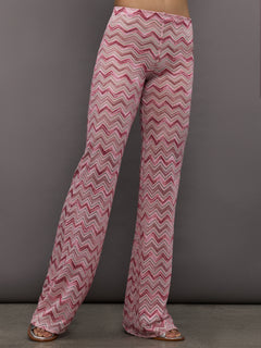 Model wears a pair of mid rise wide leg pink chevron patterned pants. 