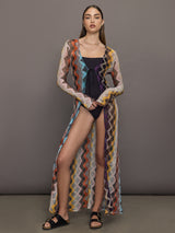 Model wears long cover-up with chevron pattern and subtle shimmer details, offering full coverage and a tie front.
