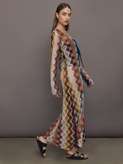 Model wears long cover-up with chevron pattern and subtle shimmer details, offering full coverage and a tie front.