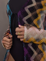 Model wears long cover-up with chevron pattern and subtle shimmer details, offering full coverage and a tie front.