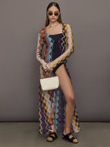 Model wears long cover-up with chevron pattern and subtle shimmer details, offering full coverage and a tie front.