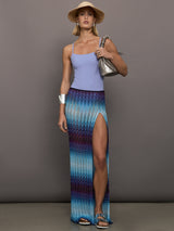 Model wears the Long skirt in multi-blue with a high slit and semi-sheer fabric, with a lightweight, more fit silhouette.