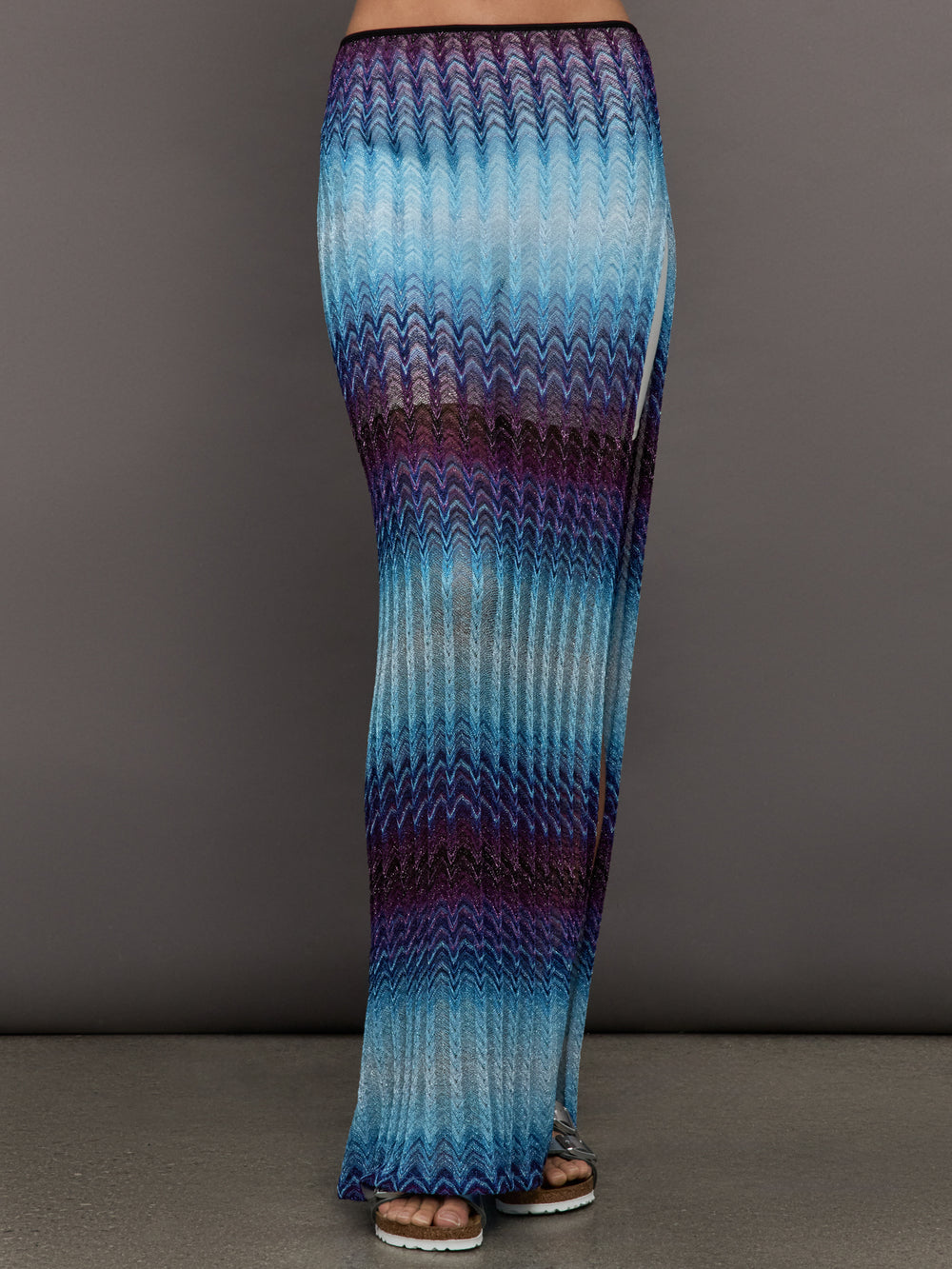 Model wears the Long skirt in multi-blue with a high slit and semi-sheer fabric, with a lightweight, more fit silhouette.