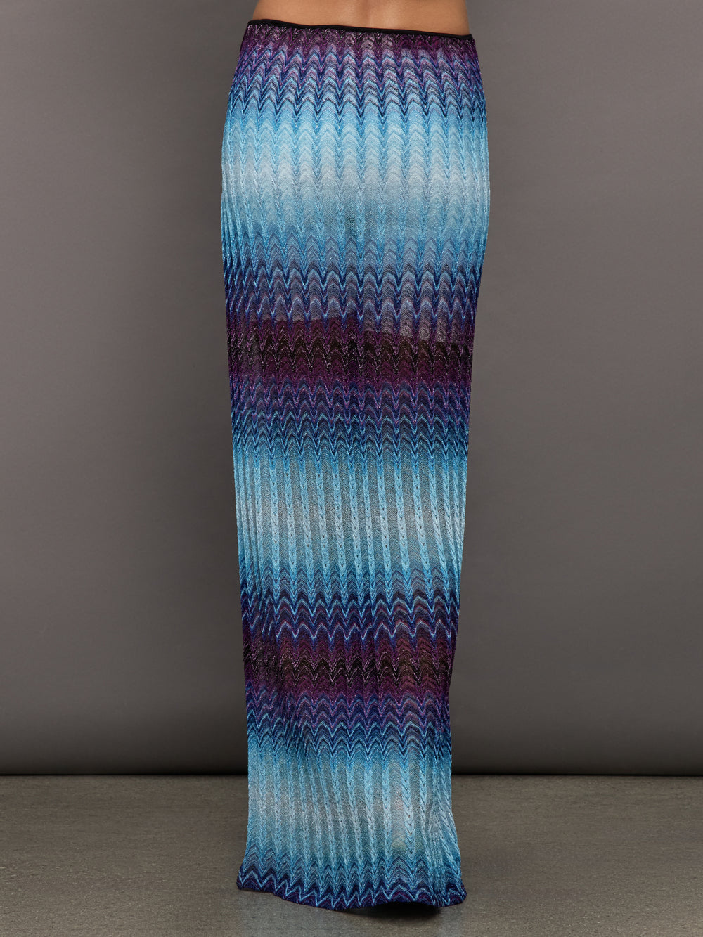 Model wears the Long skirt in multi-blue with a high slit and semi-sheer fabric, with a lightweight, more fit silhouette.