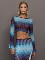 Model wears a multi-blue long-sleeve cropped top with a form-fitting silhouette.