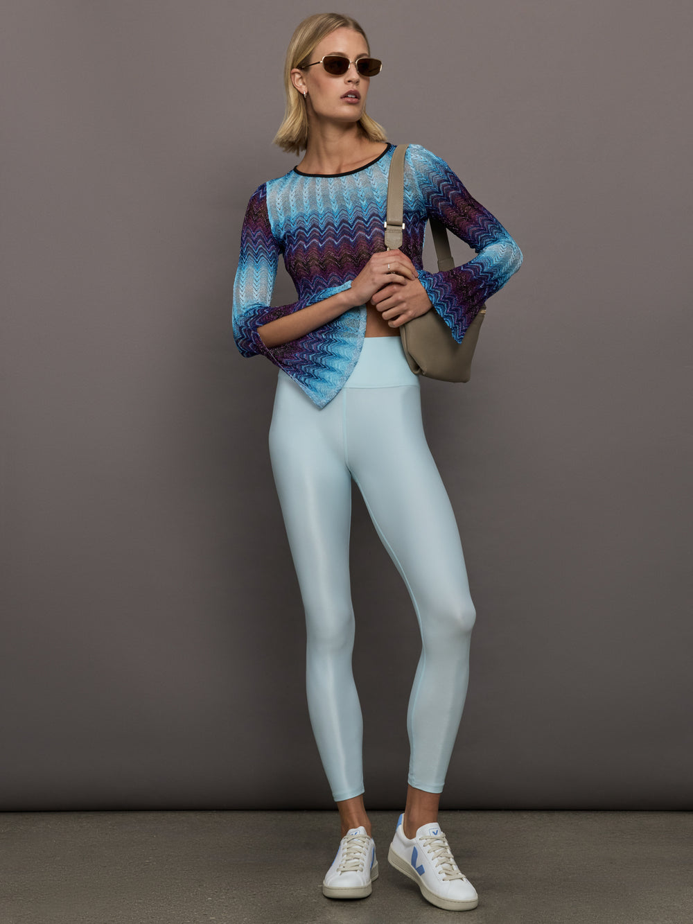 Model wears a multi-blue long-sleeve cropped top with a form-fitting silhouette.