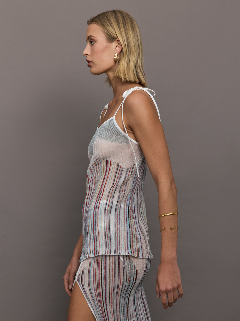 Model wearing a multicolor tank top with a loose fit and adjustable tie straps.