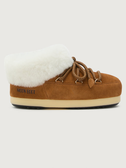 Brown slip-on shoe with white fur lining on a light gray background