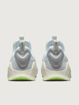 White athletic shoe with neon green sole.