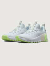 White athletic shoe with neon green sole.