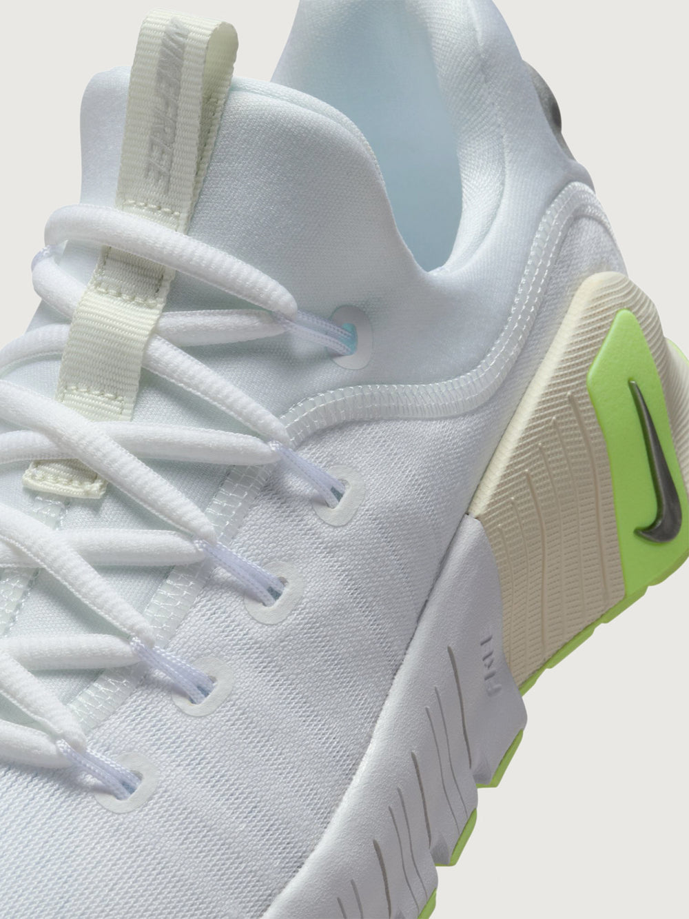 White athletic shoe with neon green sole.