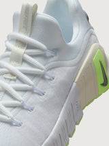 White athletic shoe with neon green sole.