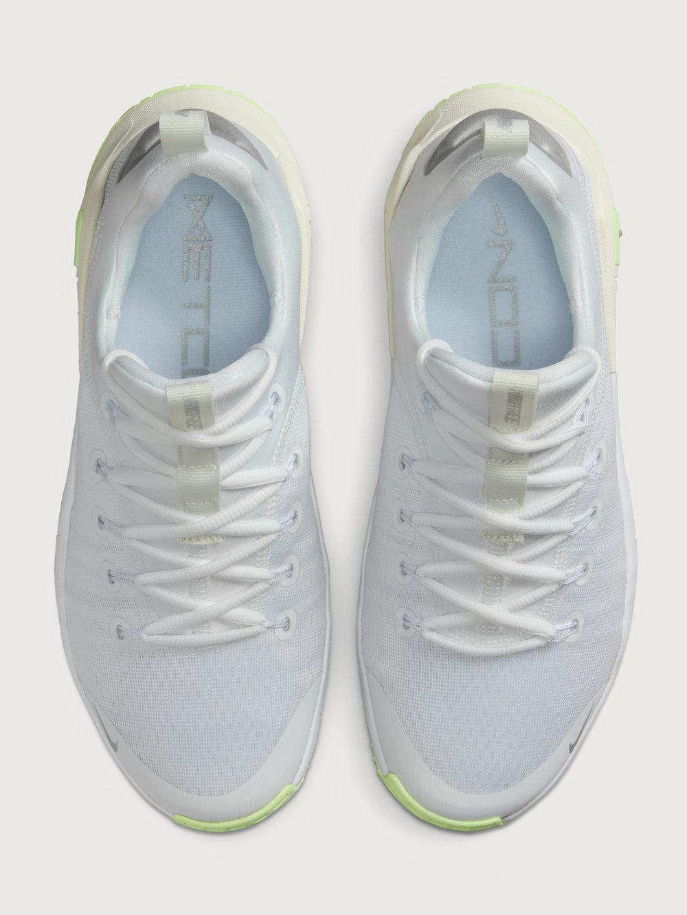 White athletic shoe with neon green sole.