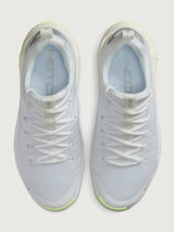 White athletic shoe with neon green sole.