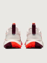 White running shoe with orange swoosh logo on a light gray background