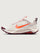 White running shoe with orange swoosh logo on a light gray background