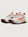 White running shoe with orange swoosh logo on a light gray background