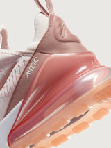 Pink and white sneaker with Nike logo.