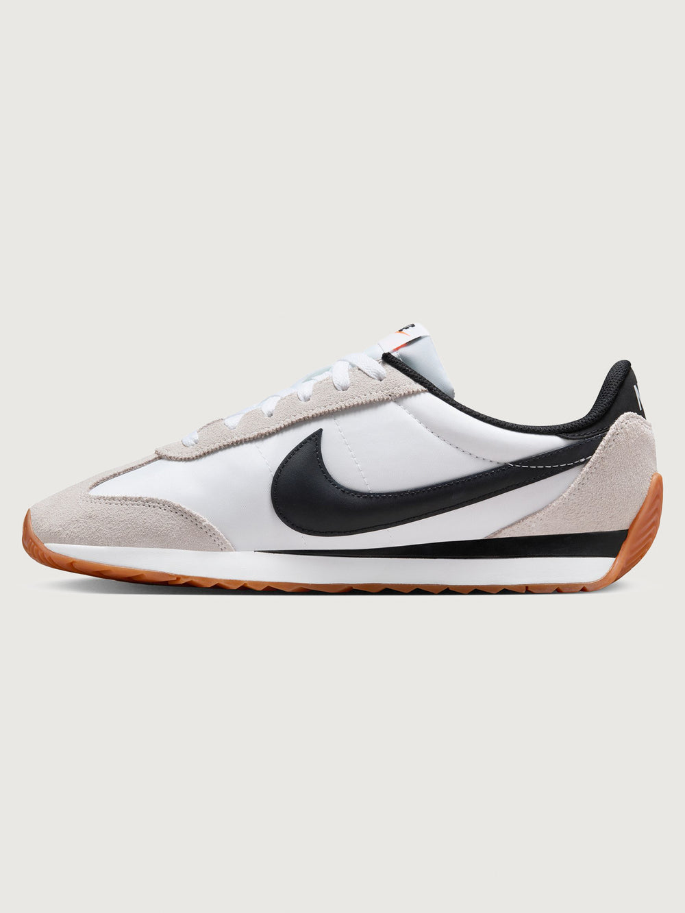 White and black sneaker with a brown sole on a light gray background