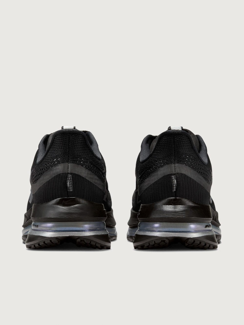 Black athletic shoes with a focus on sole design on a light gray background