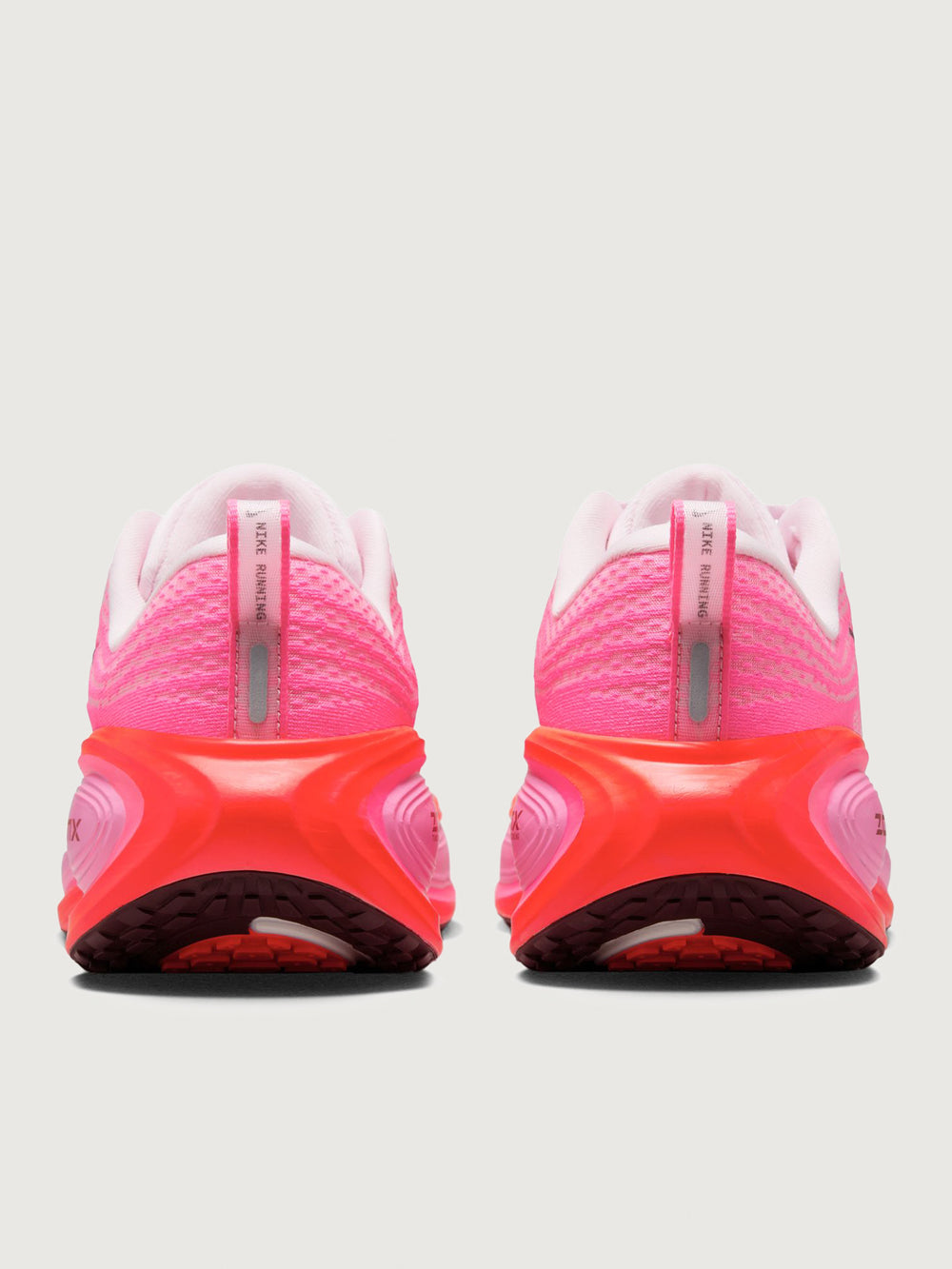 Pink running shoe with black Nike logo on a white background