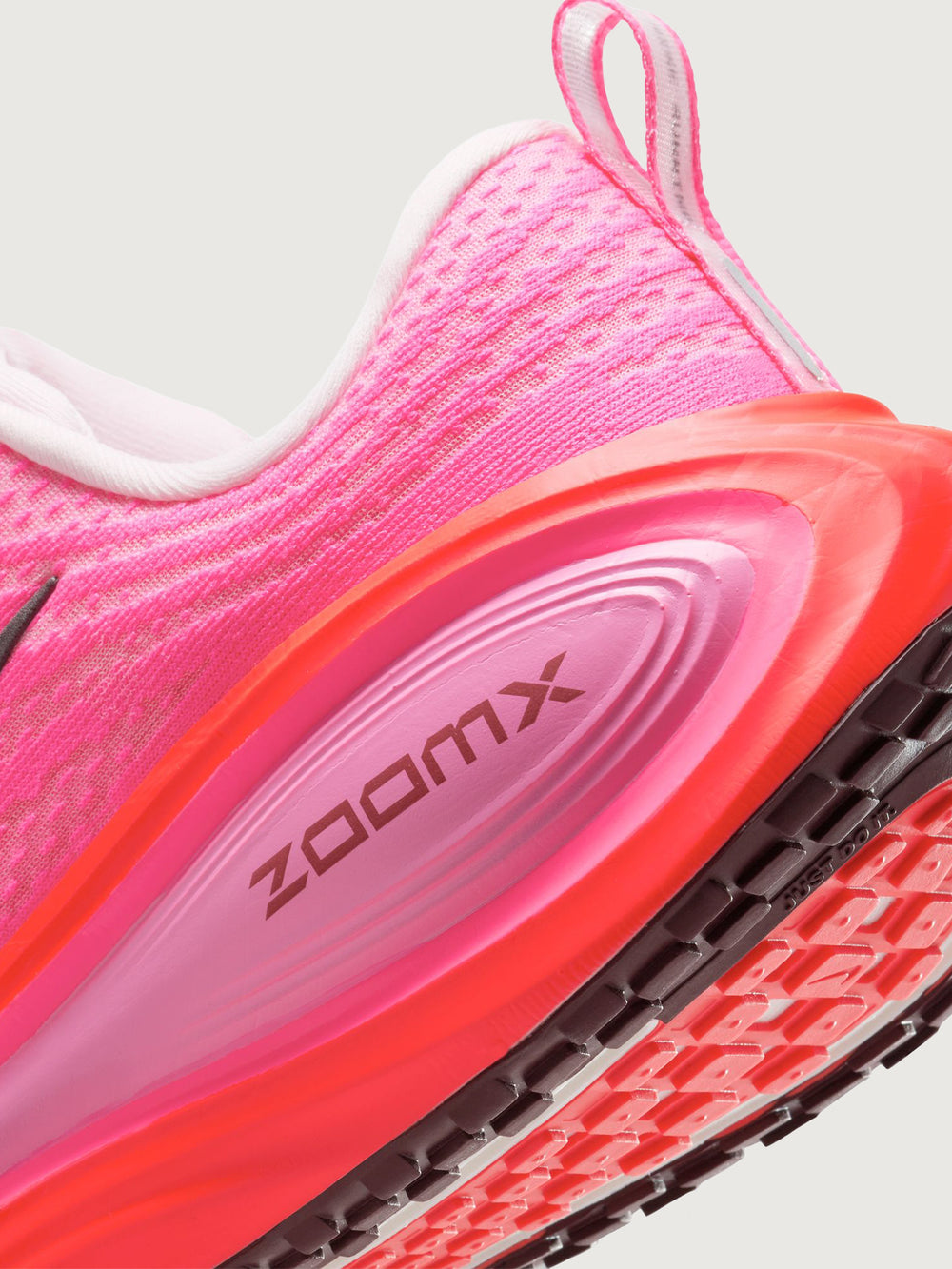 Pink running shoe with black Nike logo on a white background