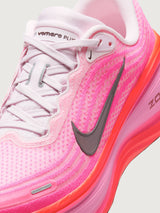 Pink running shoe with black Nike logo on a white background