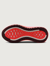 Pink running shoe with black Nike logo on a white background