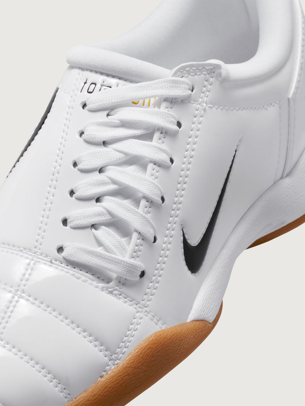 White Nike sneaker with brown sole on a white background