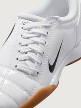 White Nike sneaker with brown sole on a white background