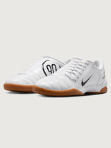 White Nike sneaker with brown sole on a white background
