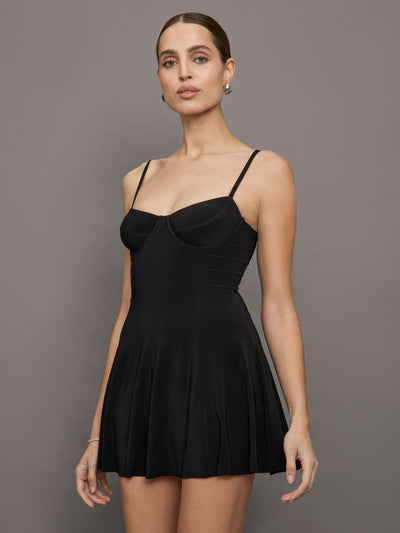 Model wears a black mini dress with a sweetheart neckline and pleated skirt with built in bodysuit perfect for tennis or pickleball. 