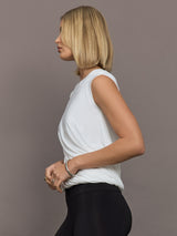 Model is wearing Sleeveless Twist Top in Snow White, side profile view.
