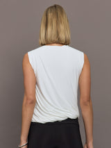Model is wearing Sleeveless Twist Top in Snow White, back view.